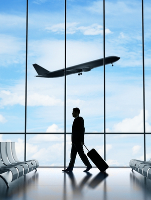 Traveller with luggage walking through an airport as a plane takes off representing the Explorer archetype of adventure and freedom