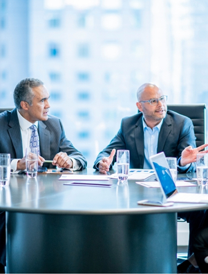 Business leaders in discussion around a boardroom table representing the Sage archetype of wisdom and informed decision making