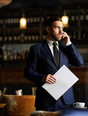 Entrepreneur in a suit holding documents and talking on the phone representing the Explorer archetype of ambition and discovery