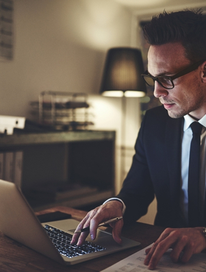 Business professional working late on a laptop representing the Citizen archetype of dedication and equality