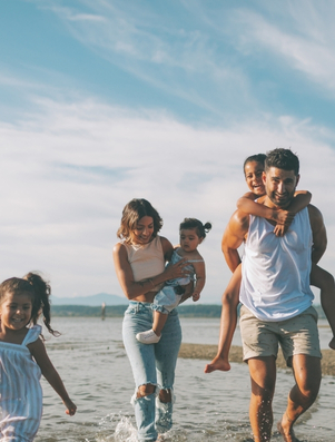 Happy family walking together on the beach representing the Caregiver archetype of love, support, and protection