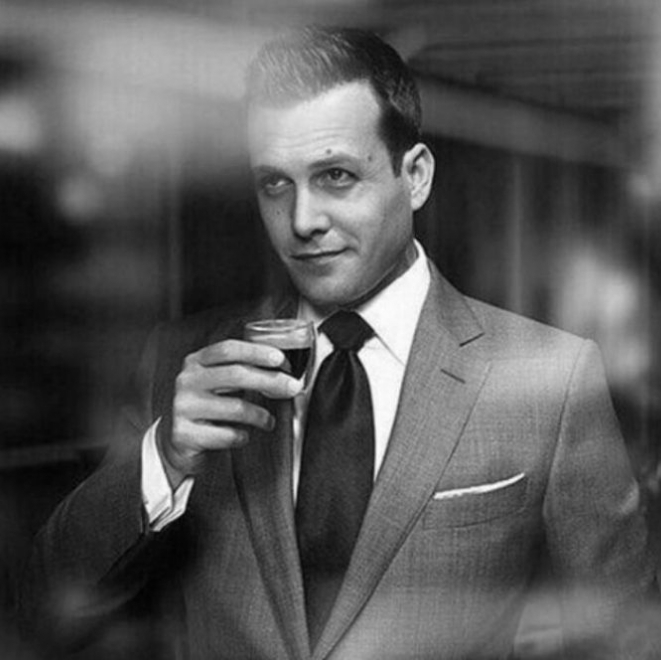 Confident man in a suit holding an espresso, symbolising authority, control, and sophistication
