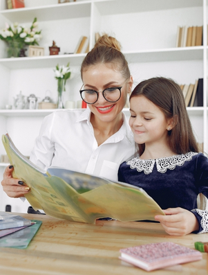 Teacher helping a young student read a book representing the Caregiver archetype of guidance and nurturing
