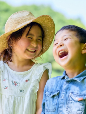 Two children laughing outdoors representing the Jester archetype of playfulness and joy