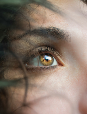 Close-up of a person’s eyes gazing upward with light reflections, symbolising vision, clarity, and imagination.