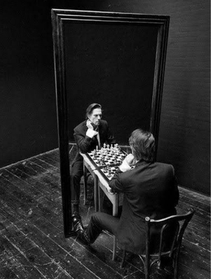 Man playing chess with his reflection in a mirror representing the Sage archetype of wisdom and intellectual growth
